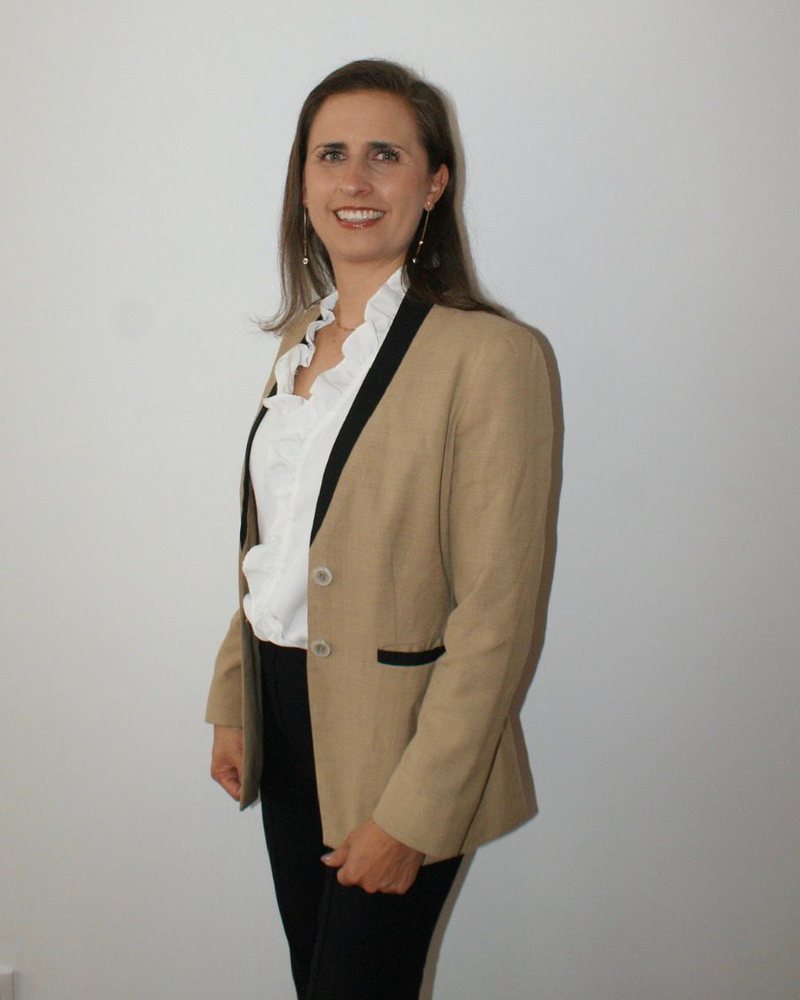 Ana Rosette con saco beige y blusa blanca, fuera de su uniforme de trabajo